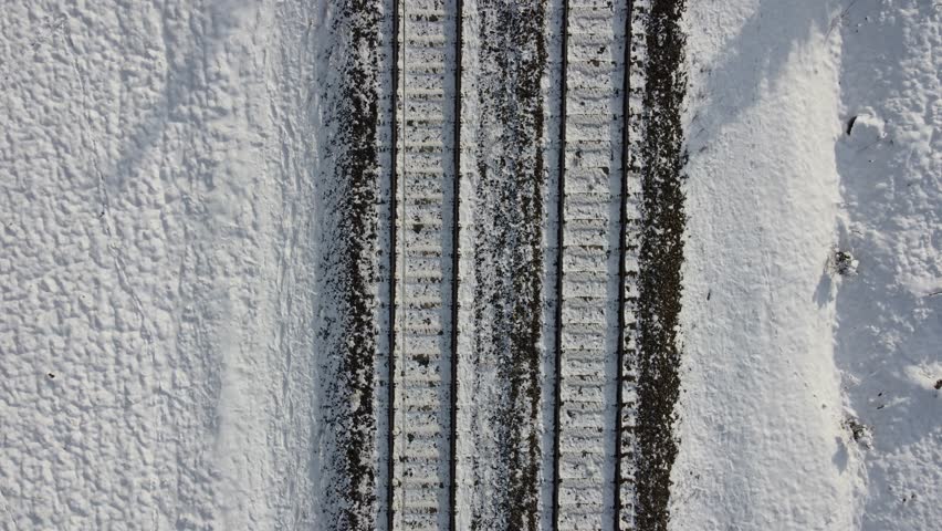 Train track rails crossing through snowy forest in winter near Munich