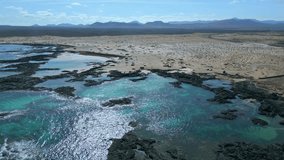 Aerial orbital clip of the natural pools and volcanic rock formations near El Cotillo in Fuerteventura Spain