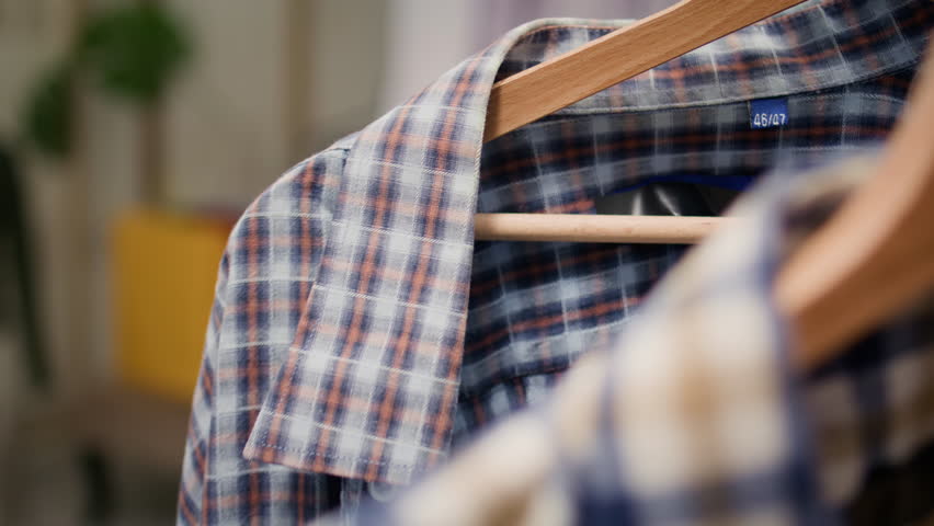 Extreme close up shot of stylish selection of shirts on hangers in high end fashion boutique showcasing trendy garments from new collection. Men shirts rotating on clothing store rack | Shutterstock HD Video #1111833095
