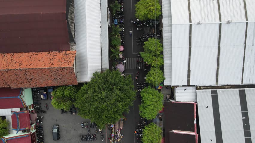Aerial view of the street and traditional market of Kranggan Yogyakarta. Crowded buildings, people and vehicles milling about.