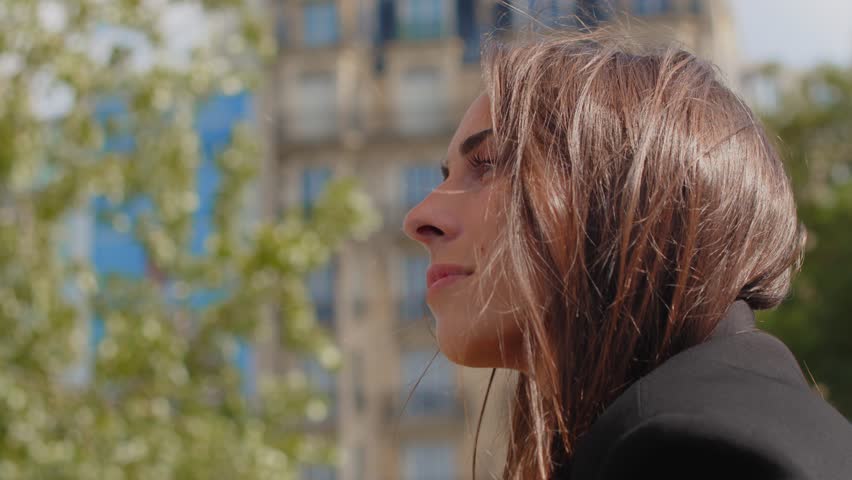 Beautiful Young Woman Contemplating With Blond Hair Blown By The Wind In Paris, France. closeup shot