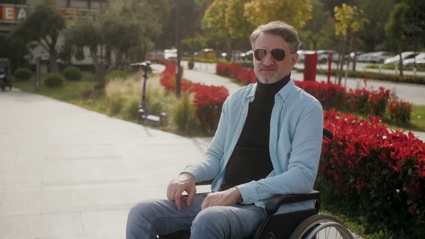Portrait of Hispanic man with disability smiling at camera sitting in wheelchair outdoors on summer day. | Shutterstock HD Video #1111833871
