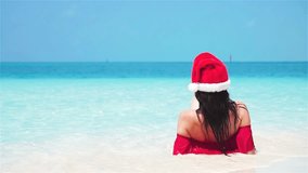 Festive Seaside, Woman in Santa Hat at Tropical Beach (Slow Motion) , Enjoy a festive seaside moment as a woman in a Santa hat and bikini walks in slow motion on a tropical beach. Experience - Powered by Shutterstock - Get 15% off with code: PIKWIZARD15