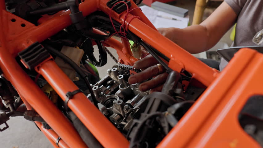50 Year Old Asian Lady at Work: Reviving the Engine of an Orange Motorcycle | Shutterstock HD Video #1111835857