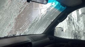 Automatic car wash view from the car cabin. Foam dripping down the car window. Advertisement for a touchless car wash. - Powered by Shutterstock - Get 15% off with code: PIKWIZARD15