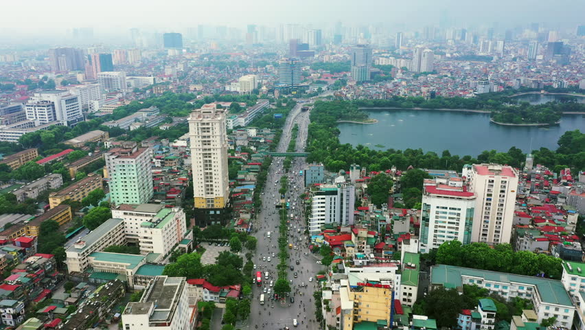 Aerial drone, city street and buildings with traffic path of Hanoi in Vietnam for transportation in an urban area. Top view of road, industrial architecture or cityscape of vehicles moving for travel