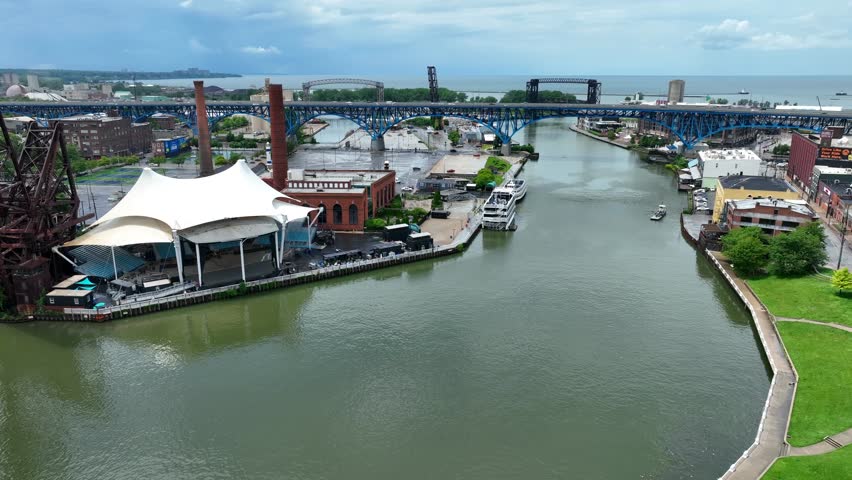 Cuyahoga River running in downtown Cleveland, Ohio. Aerial establishing shot.