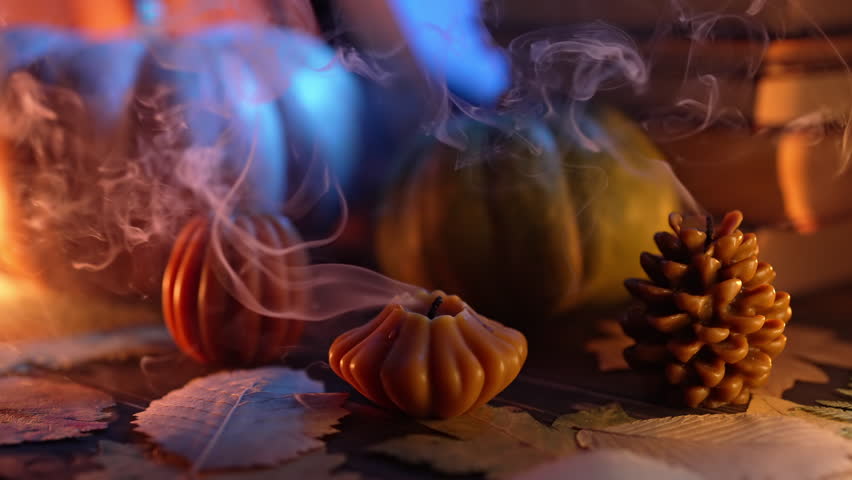 Extinguished pumpkin, cone candles on paper books background. Autumnal nostalgia | Shutterstock HD Video #1111842289