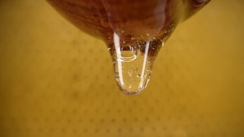 Organic honey flows from wooden dipper stick on honeycombs background. Flavour. | Shutterstock HD Video #1111842299