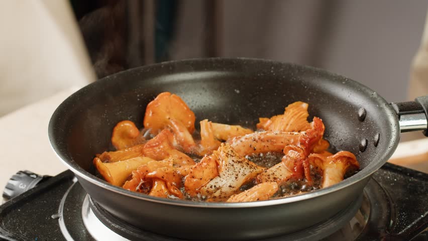 Fried chanterelle mushrooms with onion and parsley in a frying pan and the ingredients cooking i9n restaurant, autumn menu in cafe. | Shutterstock HD Video #1111842467