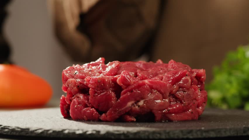 Chef cooking Raw beef meat tartar with sauce, man cutting steak tartare, making delicious french dish in modern restaurant. Fresh eco angus meat.  | Shutterstock HD Video #1111842477