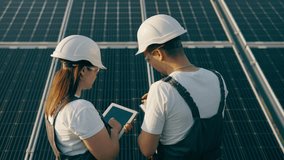 Two workers discussing the installation and effectiveness of solar panels - Powered by Shutterstock - Get 15% off with code: PIKWIZARD15