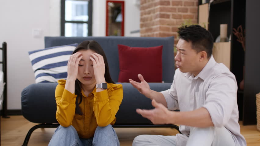 Domestic abuse, relationship crisis concept. Emotional asian middle aged man gesturing and shouting at his annoyed wife, chinese couple having quarrel at home Royalty-Free Stock Footage #1111848437