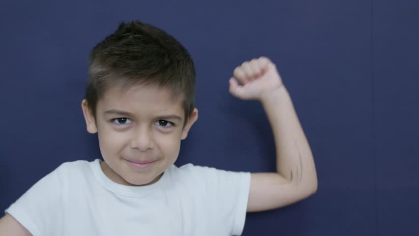 Protest. Caucasian child doesnt agree. Funny angry face expression. Isolated on blue background, slow motion. High quality 4k footage