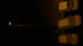 Night winter street lamp with falling snow on parked cars in slow motion. Vertical video - Powered by Shutterstock - Get 15% off with code: PIKWIZARD15