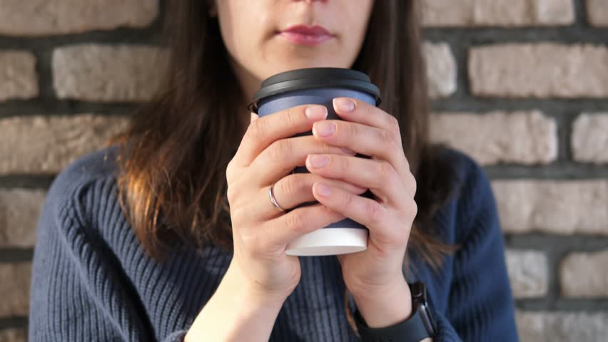 Young woman drinks a delicious hot invigorating drink coffee and enjoys life | Shutterstock HD Video #1111850069