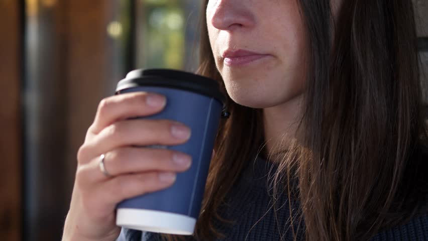 Young woman drinks a delicious hot invigorating drink coffee and enjoys life | Shutterstock HD Video #1111850071