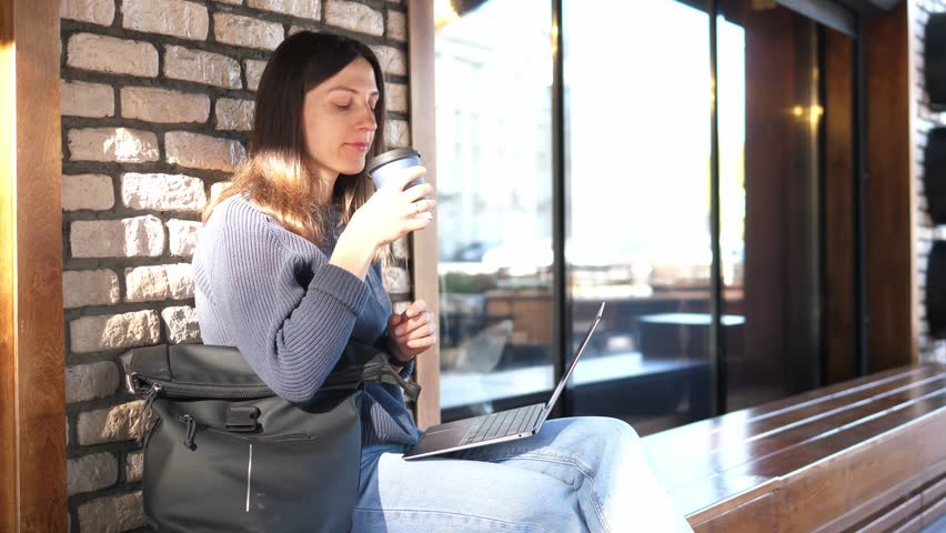 Millennial woman works on a laptop outside after being quarantined. | Shutterstock HD Video #1111850077