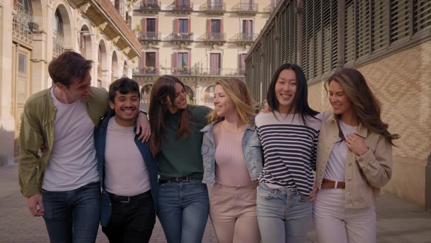 Multiracial group of smiling young friends walking hugging on street in historic city center. Happy tourists on school trip strolling embracing outdoors. Generation z tourism people enjoying together | Shutterstock HD Video #1111850569