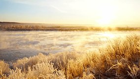 Cold winter landscape with trees covered with frost snow, river with flowing ices, fog and sun rays over horizon. Extreme low temperature weather in Siberia. High quality 4k footage - Powered by Shutterstock - Get 15% off with code: PIKWIZARD15