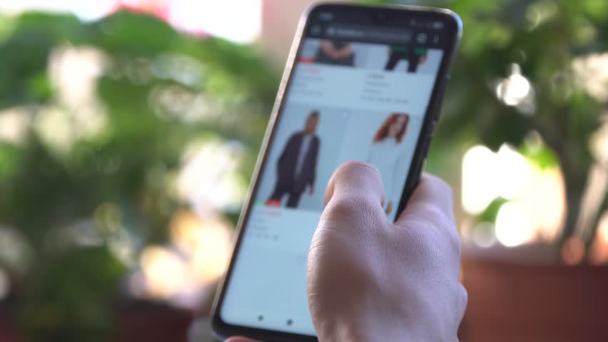 Online Marketplace. A Woman Using Smartphone Buys in Internet Shop. Customer chooses a women's clothing. Online Shopping | Shutterstock HD Video #1111857775