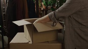 Household moving, relocation. Person open moving boxes. Woman unpacking books in new flat. - Powered by Shutterstock - Get 15% off with code: PIKWIZARD15
