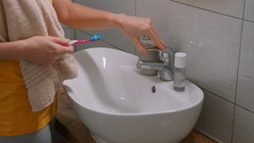 woman in the bathroom washes her toothbrush after brushing her teeth. High quality 4k footage - Powered by Shutterstock - Get 15% off with code: PIKWIZARD15
