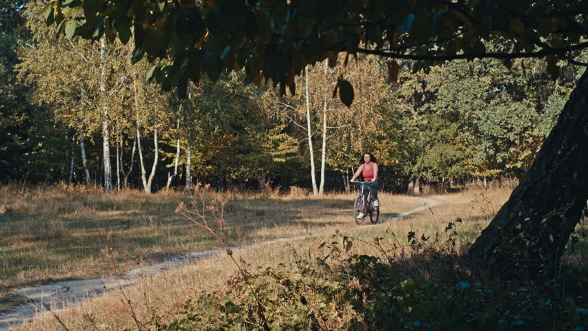 Pedaling Through Paradise: A Park Adventure with a Dynamic Woman Embracing the Outdoors on a Bike. High quality 4k footage | Shutterstock HD Video #1111868477