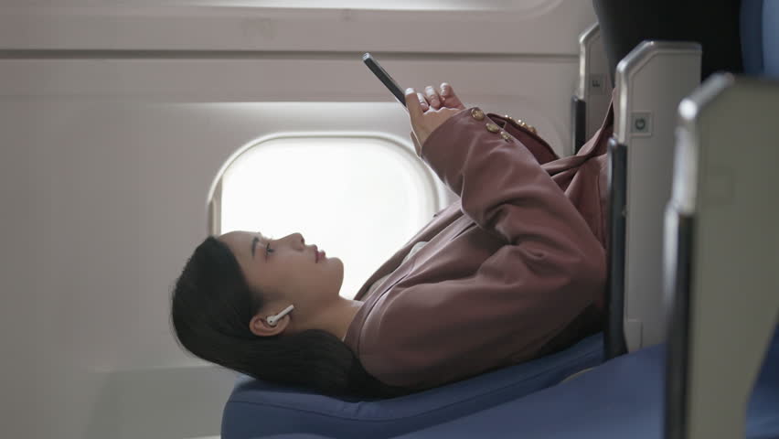 Passengers use mobile phones while on plane
 | Shutterstock HD Video #1111869015