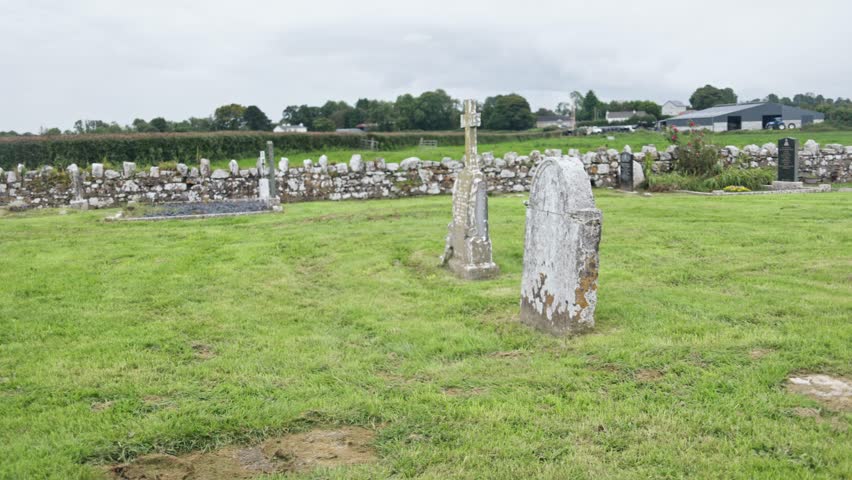 Old cemetery with stone tombstones and green lawns