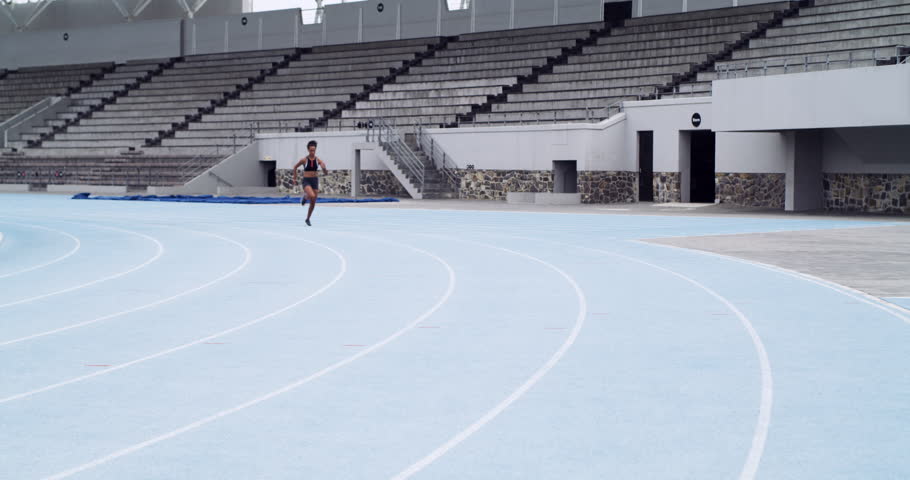 Woman, training and athlete for run, challenge and outdoors for competition, race and marathon at stadium. Female person, fitness and sports or exercise, cardio and sprint or workout and practice