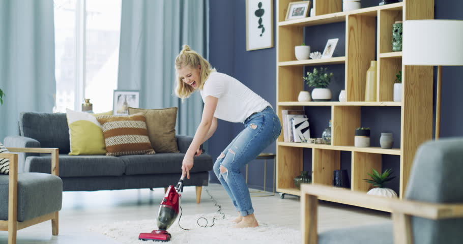 Woman, dancing and vacuum carpet with happy in living room, excited and spring cleaning in home. Young person, cheerful and housework in lounge for carefree, relax wellness and weekend in apartment | Shutterstock HD Video #1111873401