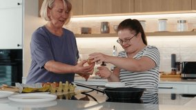 Down syndrome woman and her mother preparing breakfast together 