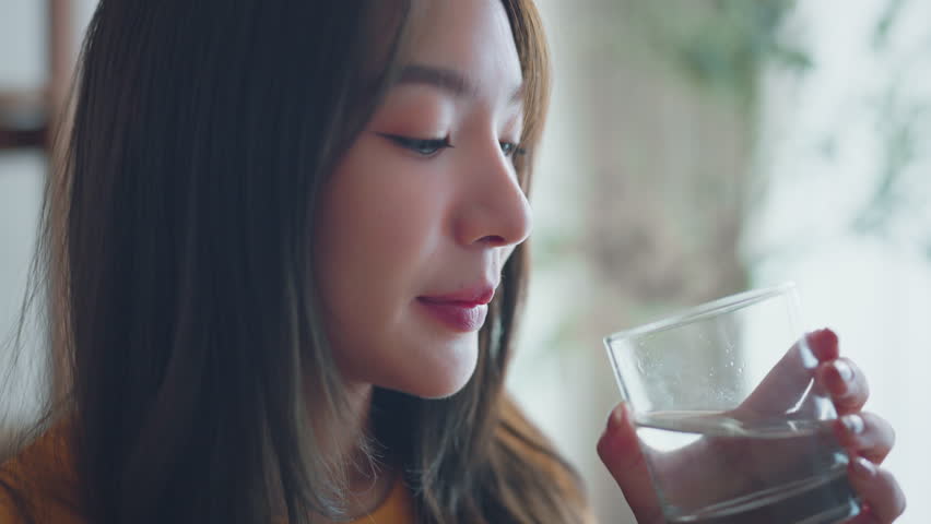 Asian woman drink water start new day with healthy life habit, Female holding glass drinking clean mineral natural still water in living room at home morning, Lifestyle healthcare concept | Shutterstock HD Video #1111876505