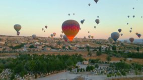 Aerial video. Captured against the canvas of the Cappadocian sky, this video showcases the enchanting spectacle of a hot air balloon festival. The vibrant balloons rise gracefully over the valleys of