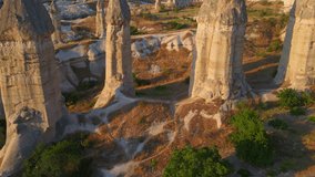 In this mesmerizing aerial stock video, we traverse Love Valley, Cappadocia, Turkey, where nature's artistry has carved a surreal landscape of distinct-shaped rocks.