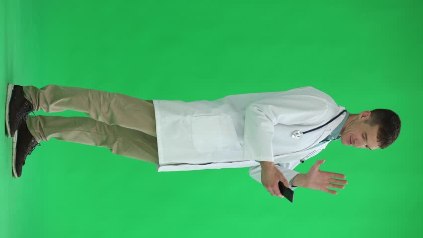 Male doctor on a green background. uses the phone | Shutterstock HD Video #1111878575