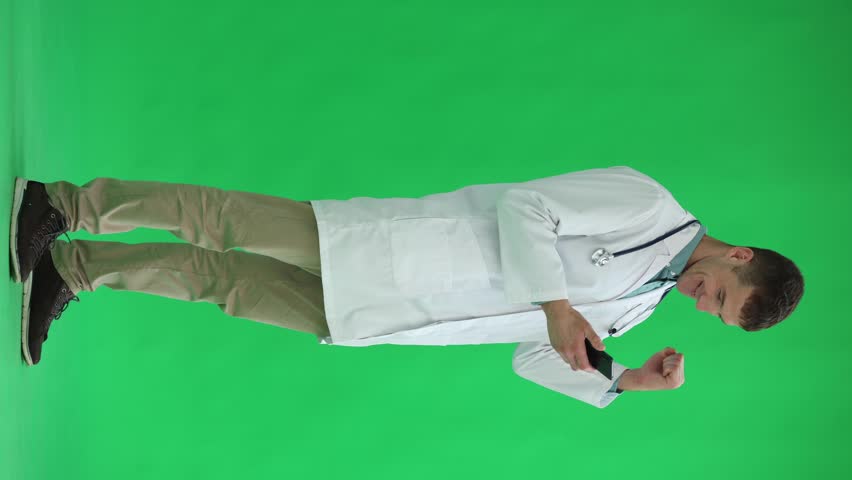 Male doctor on a green background. uses the phone | Shutterstock HD Video #1111878585