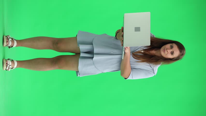 Woman on a green background. uses a computer | Shutterstock HD Video #1111878651