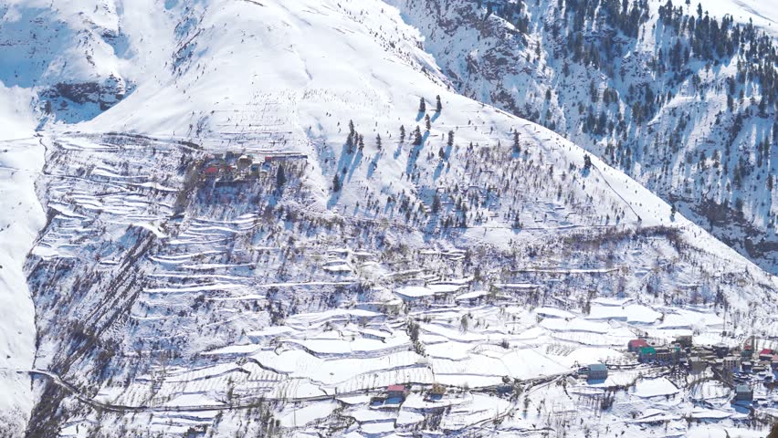 4K shot of village on a mountain covered by white snow after snowfall during the winter season in the Himalayan mountain range at Lahaul and Spiti in Himachal Pradesh, India. Village covered in snow.  | Shutterstock HD Video #1111880777
