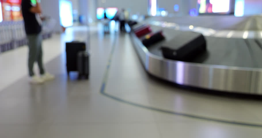 Empty arrivals hall of international airport, man stand by baggage carousel, waiting for his suitcase. Blurred view of luggage reclaim area in big and modern terminal | Shutterstock HD Video #1111883893