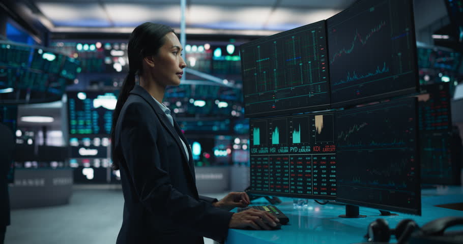 Young Female Stock Exchange Broker Working on Computer with Multi-Screen Workstation with Real-Time Stocks, Commodities and Exchange Market Charts. Professional Asian Investment Agent in Office Royalty-Free Stock Footage #1111884097