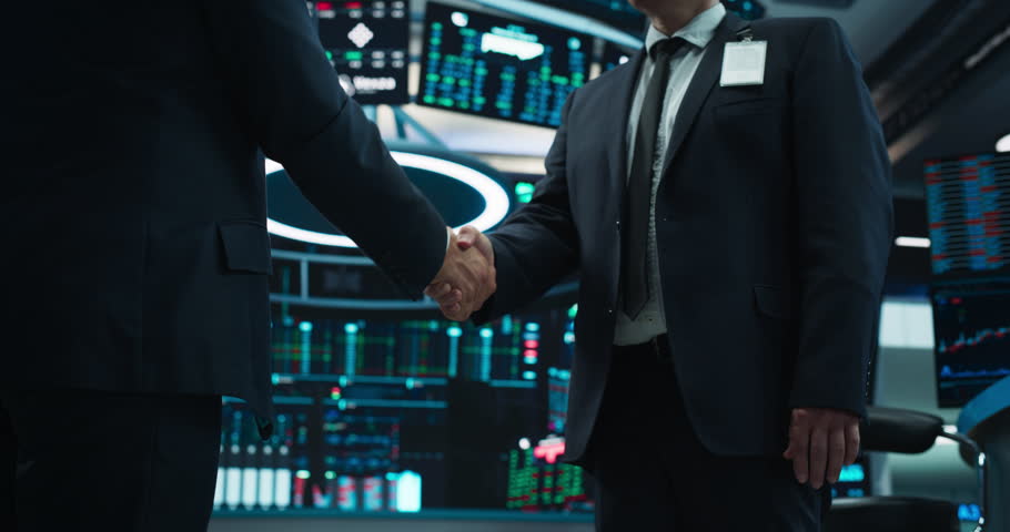 Two Anonymous Stock Market Traders Shaking Hands in a Technologically Advanced Office with Multiple Computer Screens with Real-Time Financial Data, Economy Forecasts and Predictions | Shutterstock HD Video #1111884409