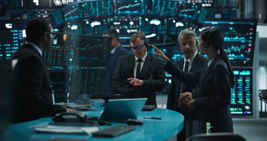 Professional Diverse Team of Male and Female Traders Working at a Modern Stock Exchange Company. Agents and Brokers Communicating Buy and Sell Orders while Talking to Clients on a Phone Call