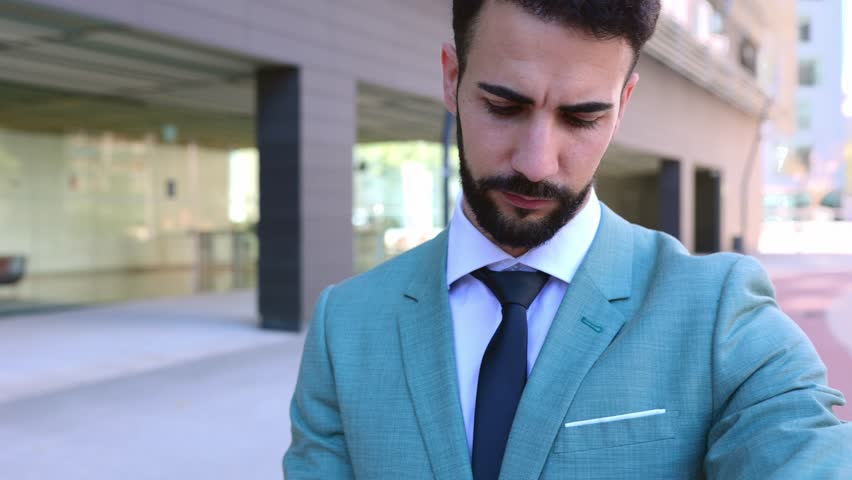 Professional corporate young adult businessman checking time on watch while standing outdoors. | Shutterstock HD Video #1111885351