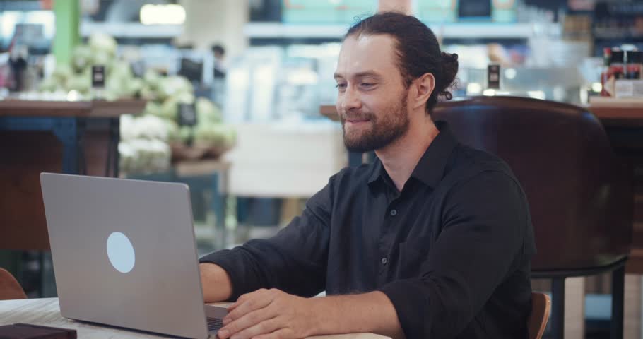 Business man sitting at laptop computer says yes to a successful startup. An excited guy in euphoria rejoices at a victory or a successful startup looking at the laptop screen.