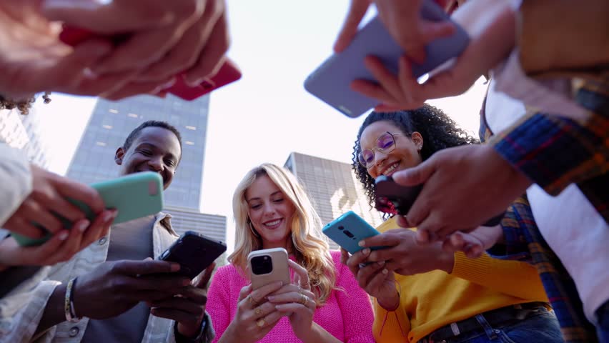 Happy group of young people using mobile phones outdoors. Teenage friends having fun together watching social media content on smart cell phone app, connected online. Technology lifestyle concept. | Shutterstock HD Video #1111887361