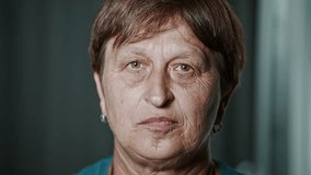 Portrait of an elderly woman with green deep-set eyes, close-up. Wrinkled face of a retired lady. Sad elderly woman looking straight into the camera. - Powered by Shutterstock - Get 15% off with code: PIKWIZARD15