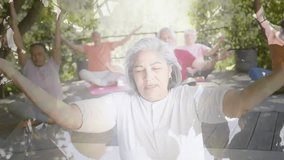Animation of spots of light and trees over diverse senior people practicing yoga in garden. Yoga, senior lifestyle, fitness, active lifestyle and retirement concept digitally generated video.
