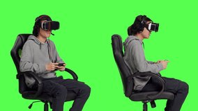 Gamer uses virtual reality for gameplay with mobile phone app, sitting on gaming chair in isolated greenscreen studio. Asian person playing multiplayer action video games with vr.